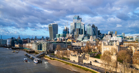 Fototapeta na wymiar London panorama from iconic Tower Bridge in western direction on a sunny winters day. Modern skyline of tall buildings in town center and banks of river Thames with Tower castle, pier and vessels. 