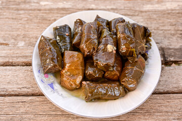 Dolmades - stuffed grape leaves  rolls  with rice the Greek way on wooden table .Stuffed greek wine leaves