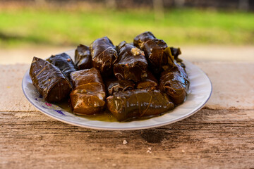 Dolmades - stuffed grape leaves  rolls  with rice the Greek way on wooden table .Stuffed greek wine leaves