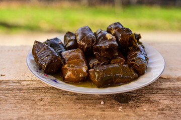 Dolmades - stuffed grape leaves  rolls  with rice the Greek way on wooden table .Stuffed greek wine leaves