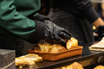 unrecognizable cook's hand with freshly baked Argentinean empanada with golden crust