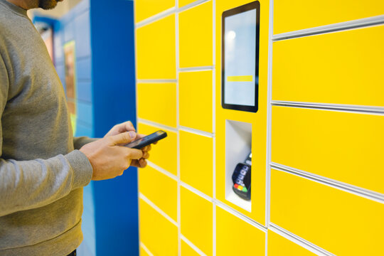 Close up of a man picks up mail from automated self-service post terminal machine