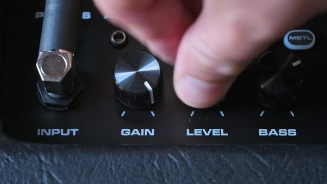 Man tunung knobs on guitar amp. 4k video footage UHD 3840x2160