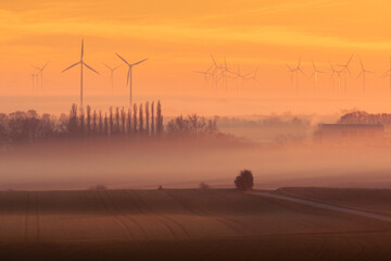 Wind power plants under in Berg, Burgenland, Austria. Foggy weather after sunset. Stunning panorama...