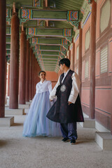 Tourist couple wearing traditional korean hanbok at the Gyeongbokgung Palace in Seoul, South Korea.