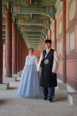 Tourist couple wearing traditional korean hanbok at the Gyeongbokgung Palace in Seoul, South Korea.