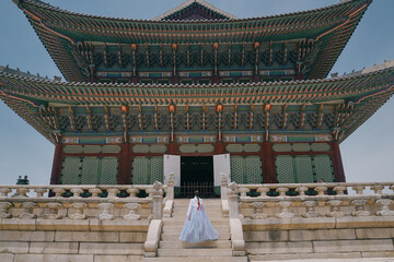 Tourist girl wearing traditional korean hanbok at the Gyeongbokgung Palace in Seoul, South Korea.