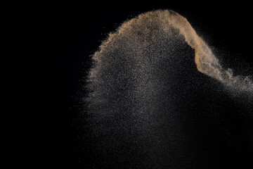Sand explosion isolated on black background.