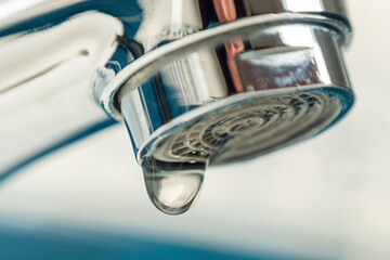 A drop of water drips from a leaky faucet