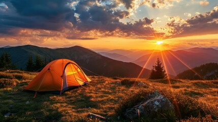 Glowing orange tent in the mountains under dramatic evening sky