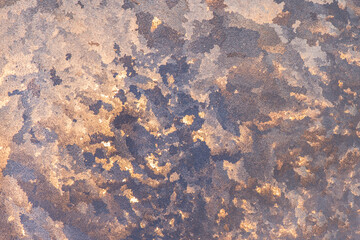 Pattern of ice gold frost on the glass of window. Winter background ant texture. Close up