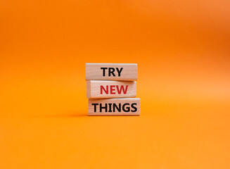 Try new Things symbol. Concept words Try new Things on wooden blocks. Beautiful orange background. Business and Try new Things concept. Copy space.