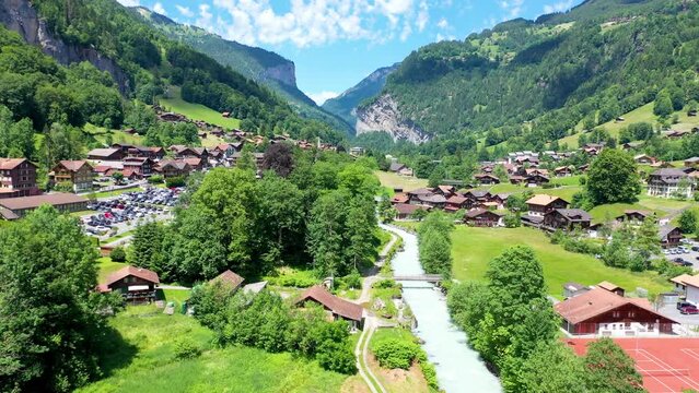Fairytale like village in Switzerland Alps with mountains and green meadows