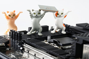 Three funny toy kittens mount a processor into a modern socket on a computer motherboard. Study of...