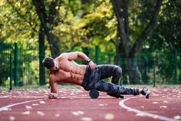 A Shirtless Man Performing an Impressive Trick on a Running Track. A shirtless man is doing a trick...