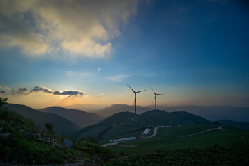 풍력 발전기가 보이는 새벽 산 위 풍경 