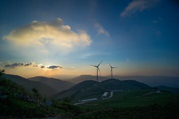 풍력 발전기가 돌아가는 아침 산 위 풍경