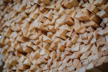 close-up of a large stack of wooden pieces with triangular ends, creating a geometric pattern with a three-dimensional effect.