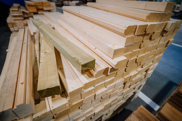 stack of freshly cut and planed wooden planks and beams