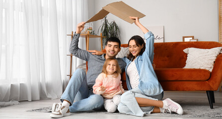Happy family with cardboard dreaming about their new house at home