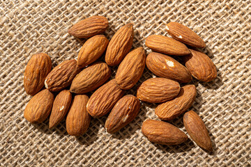 Almonds nuts close up on a textured background wood hessian