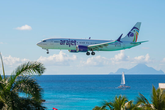 Arajet Boeing 737 Max 8 flying over Maho Beach before landing on Princess Juliana International Airport SXM on Sint Maarten, Dutch Caribbean. 