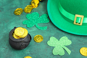 Leprechaun hat with pot of golden coins and paper clovers on green grunge background. St. Patrick's...