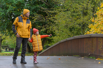 father and five-year-old daughter in fall park on bridge
