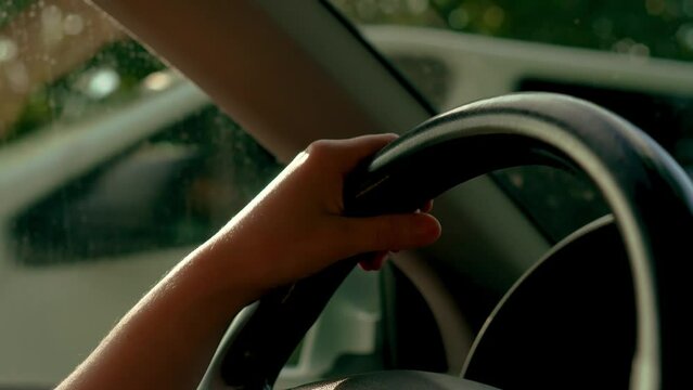 Woman driving car with hands on steering wheel to control vehicle close up. Adult female having safety ride in vehicle. Young traveling travelling by SUV