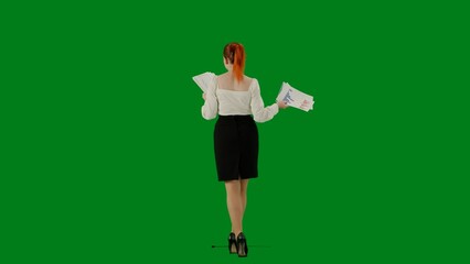 Fototapeta na wymiar Portrait of attractive office girl on chroma key green screen. Woman in skirt and blouse walking reading paper documents. Back view.