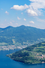Fototapeta na wymiar Mountain landscape, picturesque mountain lake in the summer morning, large panorama, landscape with fabulous lake view from the top of the mountain, with view of city. Iseo, Italy