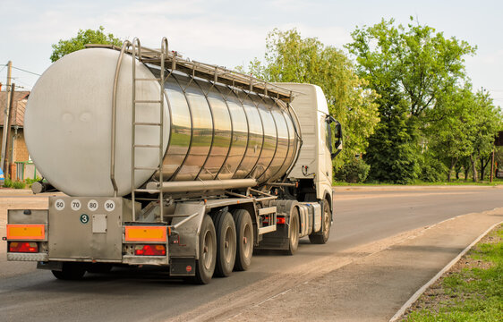 Powerful semi-trailer truck with heavy-duty three-axle tanker for high-speed intercity and international transportation on highway, panoramic shot