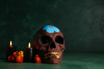 Marigold flowers with candles and painted skull on grunge green background. Celebration of Mexico's Day of the Dead (El Dia de Muertos)