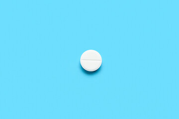 White medical pill on blue background