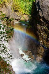 Fototapeta na wymiar Rainbow forms on a waterfall at Elk Falls, British Columbia, Canada