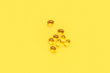 Medical capsules on yellow background