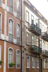 Exterior facade of historical houses with apartments in Lisbon, Portugal. Urban vintage background. Alfama district. The building is tiled with carved balconies.