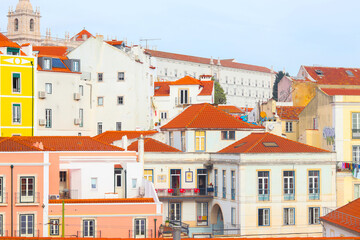 View of historical houses with red roofs, Lisbon, Portugal. Amalfa district. The Miradouro de Santa Luzia viewpoint. The Church of Sao Vicente of Fora in the background.