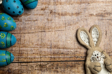 Easter Bunny and Colorful easter eggs on wooden background with copy space