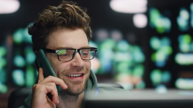 Happy developer talking smartphone at night datacenter closeup. Man ending call 