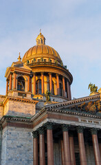 Fototapeta premium The golden dome of St. Isaac's Cathedral in St. Petersburg against the blue sky.