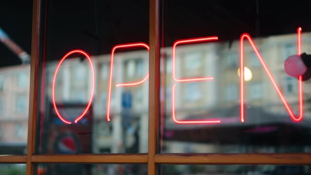 The vibrant glow of the neon open sign enhances the visual appeal of the storefront.