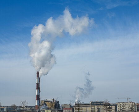 The chimney emits exhaust gases into the blue sky. The concept of air pollution and the environment.	