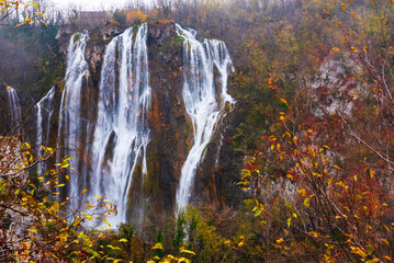 Great Waterfall in Plitvice National Park in Croatia on an autumn day, yellow foliage and turquoise...
