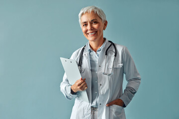 Family doctor. A female employee of a medical clinic poses on a blue background.