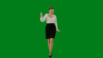 Portrait of attractive office girl on chroma key green screen. Woman in skirt and blouse walking dancing cutely, smiling looking at the camera.