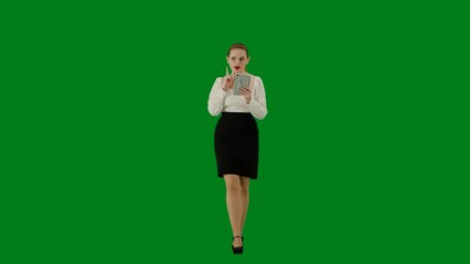 Portrait of attractive office girl on chroma key green screen. Woman in skirt walking and holding tablet, positive expression.