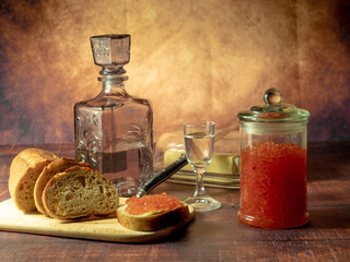 Antique-style still life with vodka and red caviar.