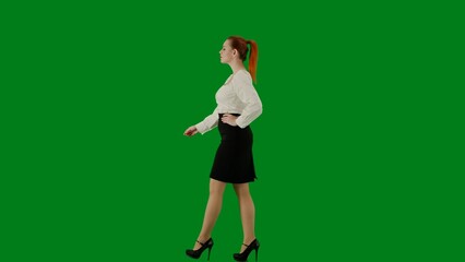 Fototapeta na wymiar Portrait of attractive office girl on chroma key green screen. Woman in skirt and blouse walking confidently, hands on waist. Side view.