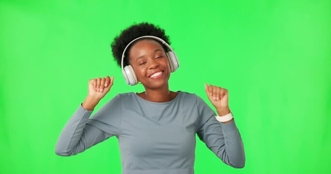 Dance, music and black woman with headphones on green screen for listening in studio isolated on a background. Radio, streaming and happy person with energy for moving, sound or audio on mockup space
